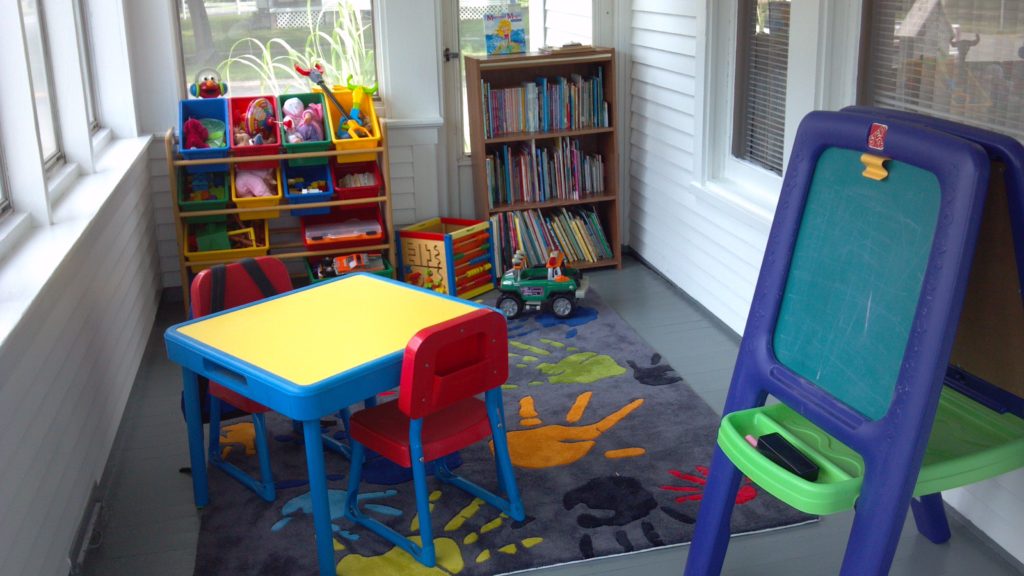 A room with toys and books on the floor.