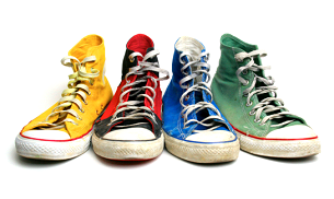 A row of different colored sneakers sitting on top of each other.