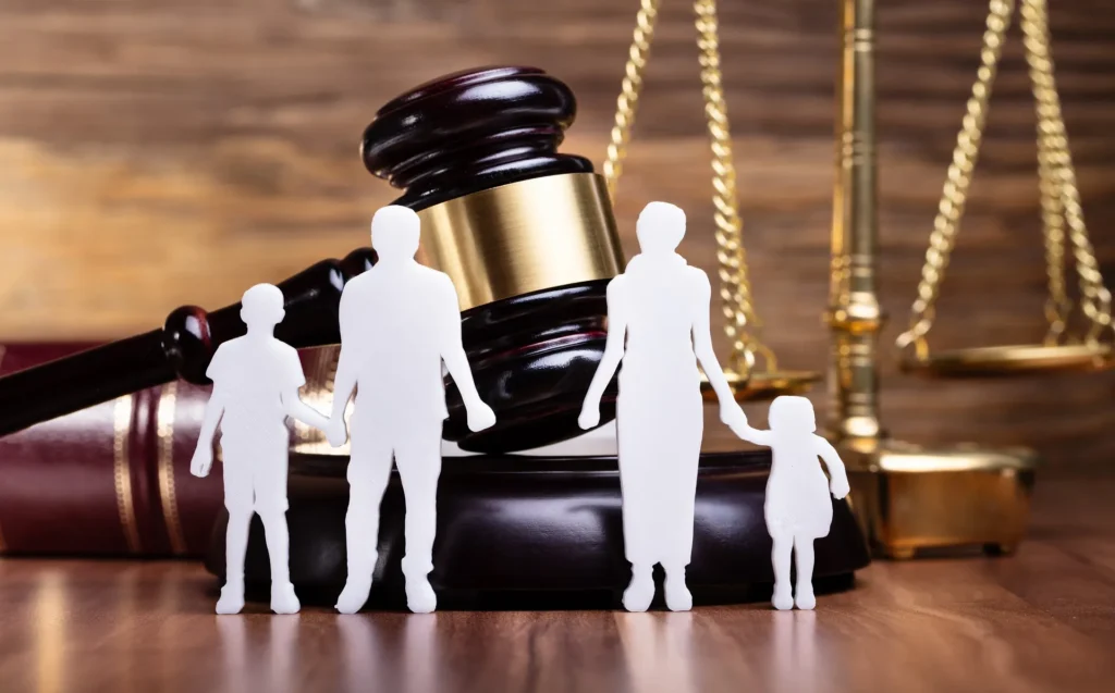 A family of four standing in front of a judge 's gavel.