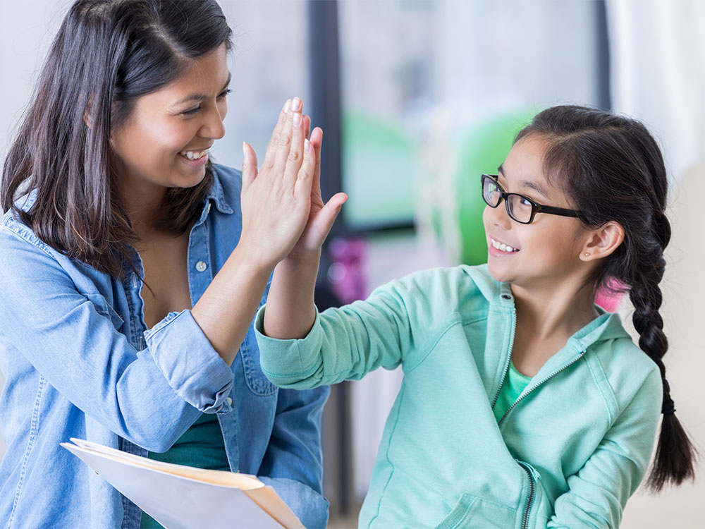 A woman and girl giving each other high five.